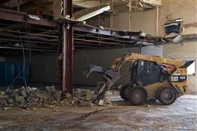 Demolition: A Caterpillar 262D skidsteer moves material inside of a building during a demolition project. 