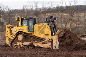 : A Caterpillar D8T strips soil.